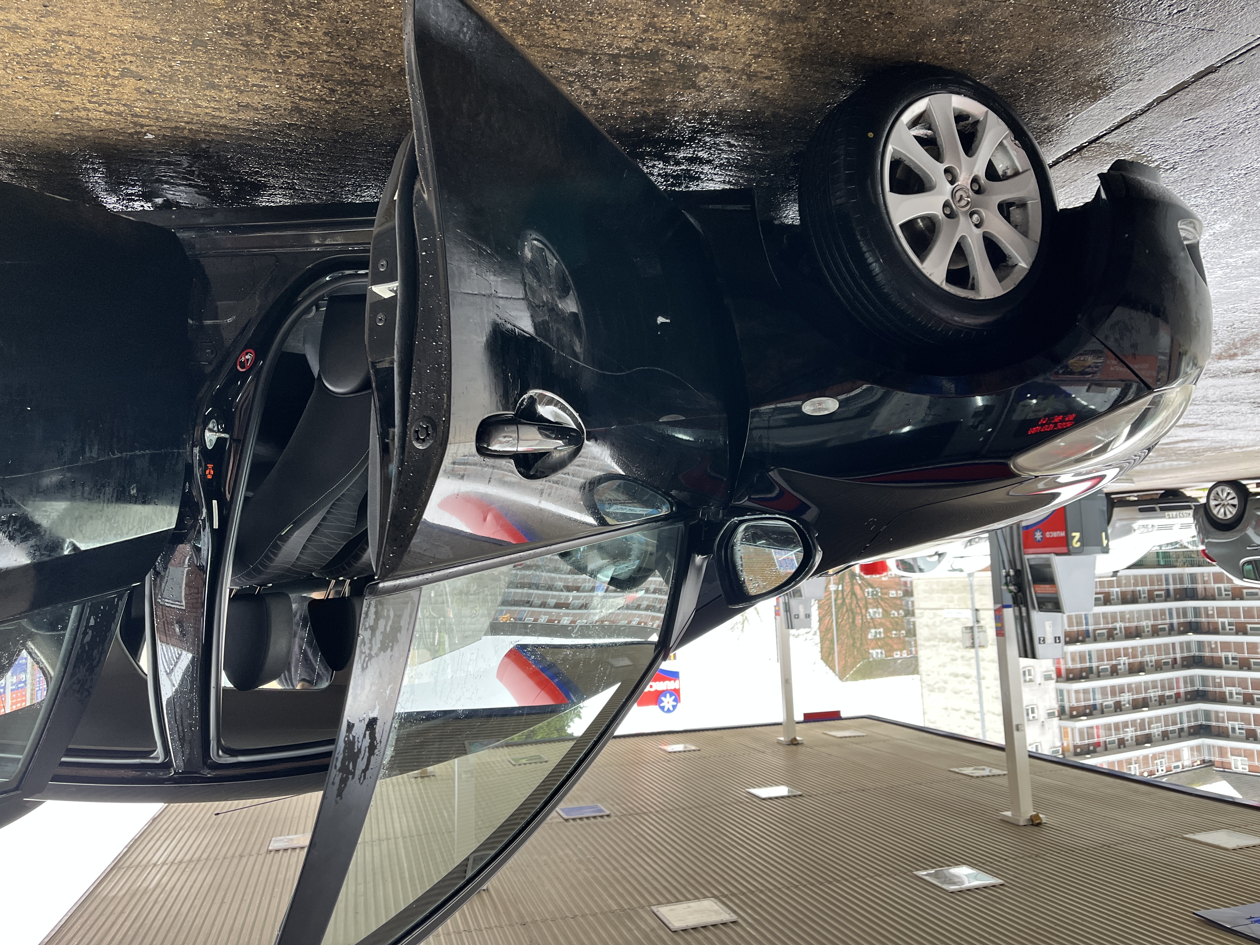 Hand-washing a car with a pressure washer at the customer's door